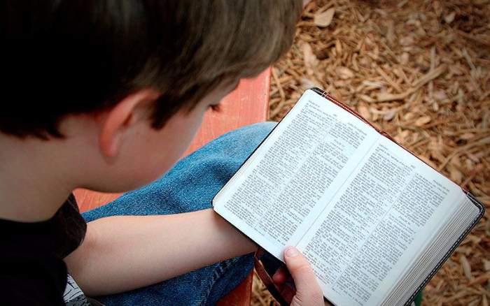 Gambar: Seorang anak membaca Alkitab.